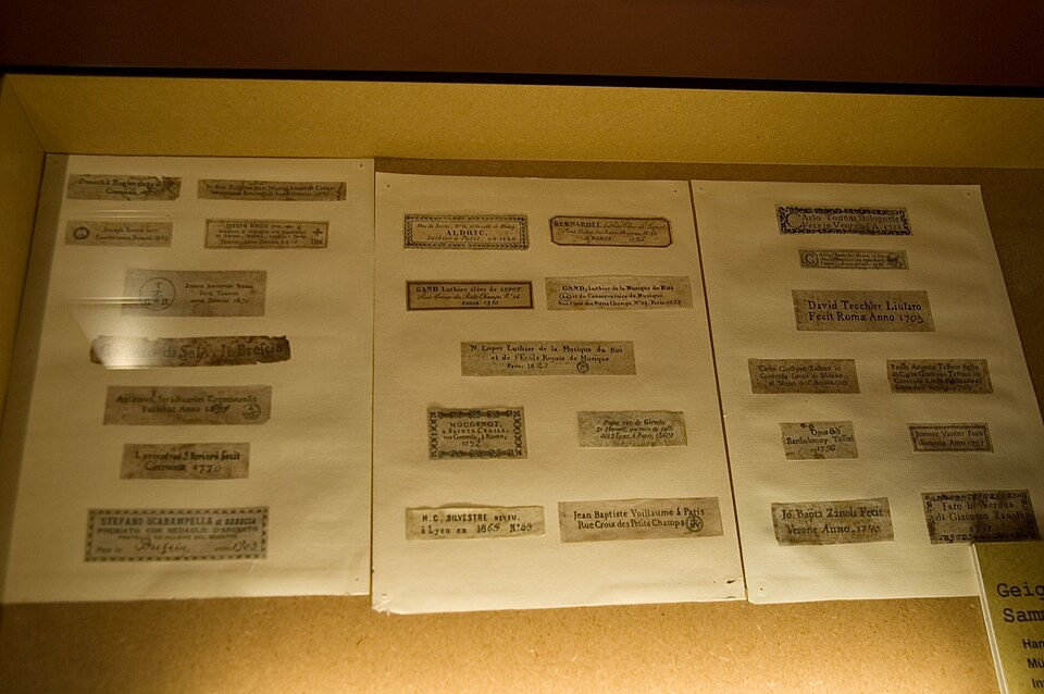 Museum display of real paper labels removed from violins
