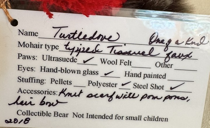Handwritten Hager Bears specification card for a bear named Turtledove, listing fur type, paws, eyes, stuffing, accessories and the year 2018