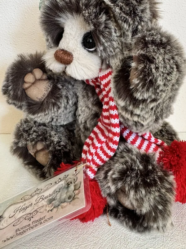 Seated Hager Bears artist teddy bear in grey tipped faux fur with its printed maker tag resting against it