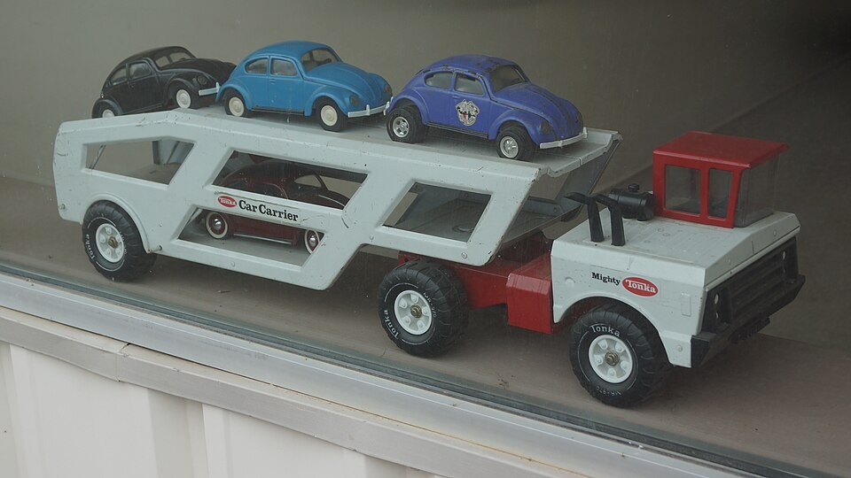 White Mighty Tonka car carrier displayed with several toy cars on its two decks