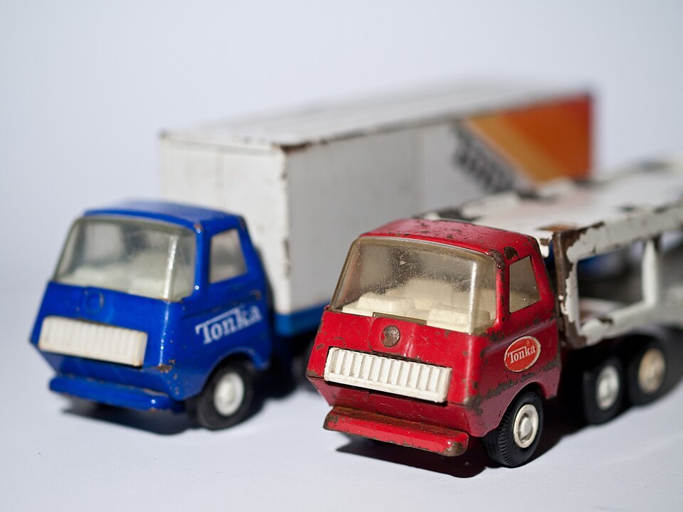 Red and blue Tonka truck cabs with chipped paint, visible door logos, and plastic windshields